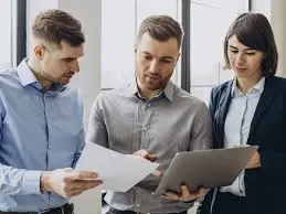 Tres asesores comprobando y comparando nóminas y contratos